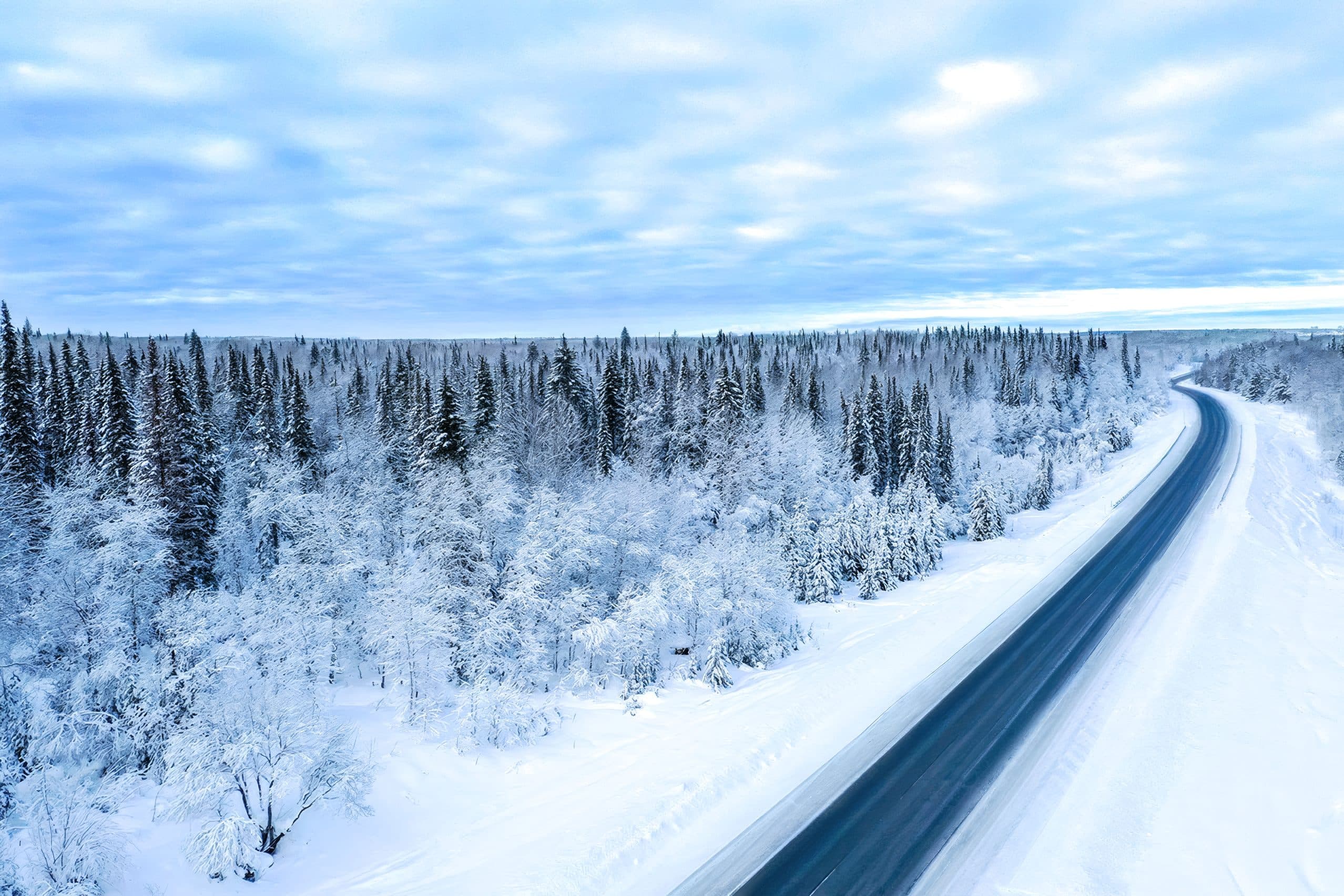 Winter highway through snow-covered forest